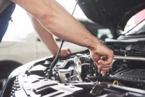 a mechanic is repairing the engine of the car