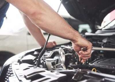 a mechanic is repairing the engine of the car