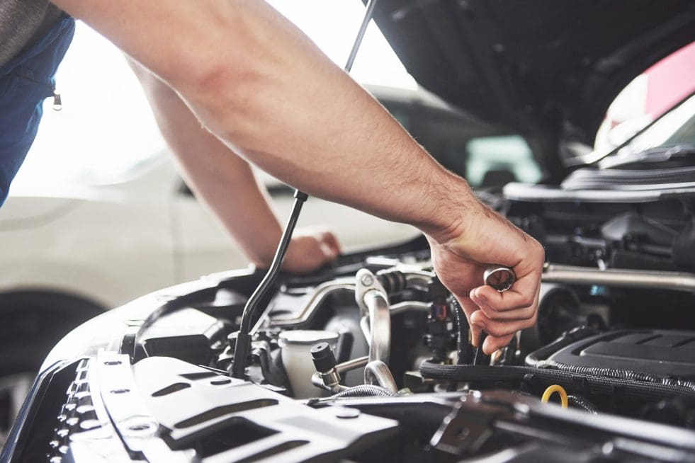 a mechanics hand holding a wrench providing auto repair services